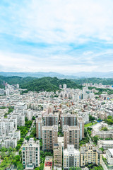 Poster - Asia Business concept for real estate and corporate construction - panoramic modern cityscape building bird eye aerial view with green mountain under sunrise and morning blue bright sky, shot in Taipe