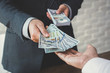 © Atstock Productions - Businessman giving or paying money to a man