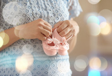 Pregnant Woman Holding Pink Baby Booties