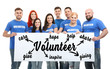 © Africa Studio - Group of people holding poster with word VOLUNTEER on white background