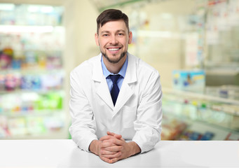 Sticker - Young handsome pharmacist standing at table on white background