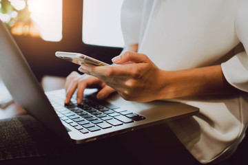 Soft focus of woman hand working with phone on desk in coffee shop. Vintage tone