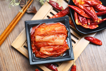 Korean kimchi in black plate on bamboo