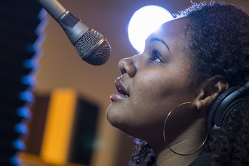 Wall Mural - Black female singing in a recording studio, close up