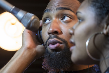 Wall Mural - Black male and female singing in a recording studio