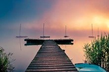 Morning Foggy Lake Landscape. Wooden Pier And Boats On The Lake.