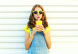 © rohappy - Fashion portrait pretty cool girl drinks a juice from cup over a white background