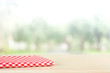 © Atstock Productions - Red checkered cloth on wood table top in blur green background of trees in the park