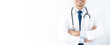 © Atstock Productions - Smiling doctor standing and crossing his arms in white blind background
