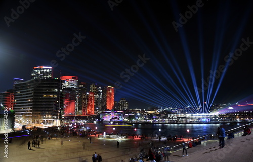 Obraz na płótnie City lights and laser show in Circular Quay during the Sydney Vivid show, the free annual outdoor event of light music and ideas. View from Sydney Opera House.