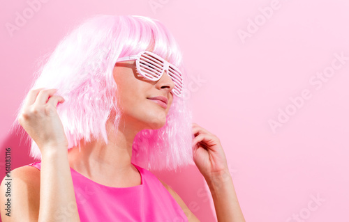 Beautiful woman in a bright pink wig on a pink background