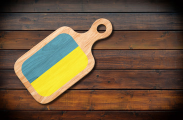 Wall Mural - Concept of Ukrainian cuisine. Cutting board with a Ukraine flag on a wooden background