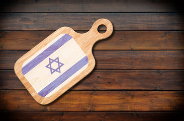 Wall Mural - Concept of Israeli cuisine. Cutting board with a Israel flag on a wooden background