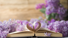 Opened Book On The Table With Pages Like Heart And Flowers