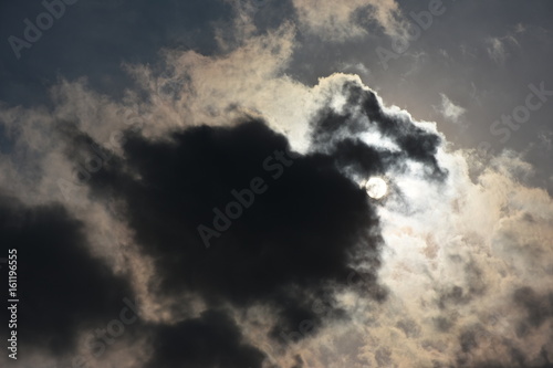 雲から透けて見える太陽 明暗 光と影 命運 夢などのイメージ 黒い雲などに文字入れスペース 中央の黒い雲部分にタイトルを入れるとインパクト大 Stock Photo Adobe Stock