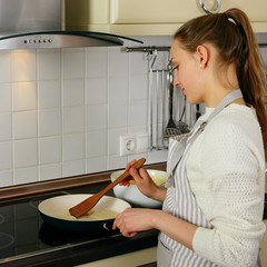 Shef woman housewife frying pancakes on kitchen