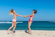 © belart84 - Two happy female friends having fun and swirling on the tropical beach of Bali island, Nusa Dua, Indonesia.
