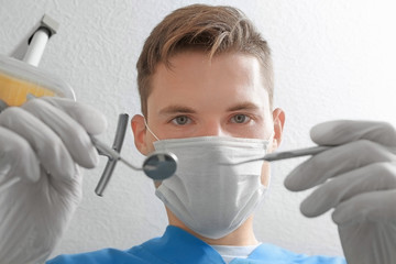 Wall Mural - Portrait of young dentist with hook and mirror