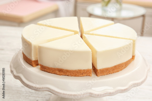 Dessert stand with delicious sliced cheesecake on table Fototapet