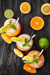 Wall Mural - Glasses of Tequila Sunrise cocktail with citrus slices on wooden table