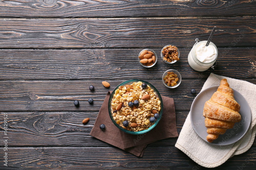 Delicious muesli with berries and almonds on wooden table