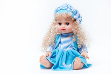 Blond Baby Doll In Blue And White Striped Dress And Hat On White Background