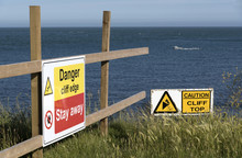 Danger Signs On The Cliff Edge At Peveril Point In Swanage Bay Dorest England UK