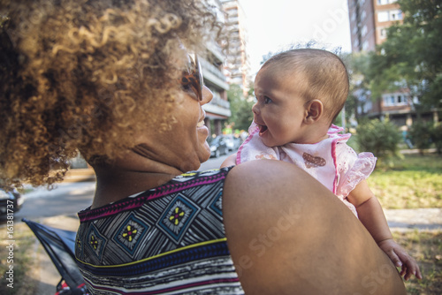 Foto African american mother kissing her adorable mixed race baby daughter