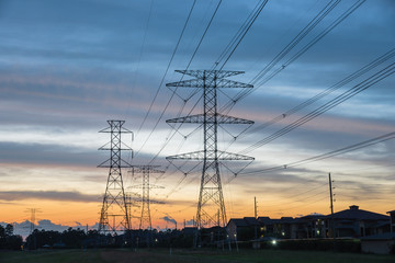 Wall Mural - Group silhouette of transmission towers (power tower, electricity pylon, steel lattice tower) at twilight in Humble, Texas, US. Texture high voltage pillar, overhead power line, industrial background.