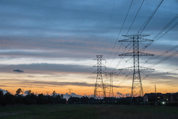 Wall Mural - Group silhouette of transmission towers (power tower, electricity pylon, steel lattice tower) at twilight in Humble, Texas, US. Texture high voltage pillar, overhead power line, industrial background.