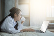 © ibravery - Asia woman working on bed with laptop
