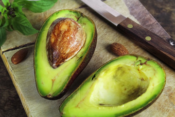 Wall Mural - Fresh avocado on cutting board over wooden background