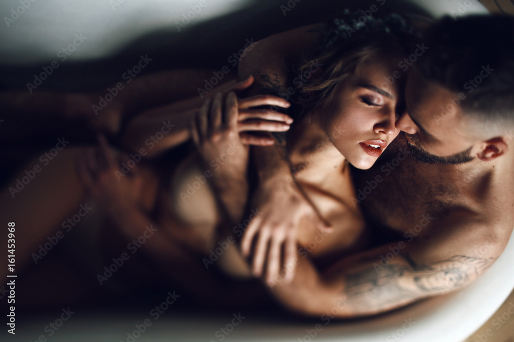 Man hugs woman from behind lying in the bath - obrazy, fototapety, plakaty 