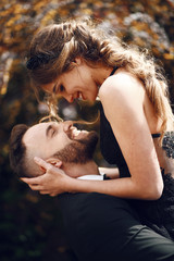 Man holds his smiling woman in black dress up