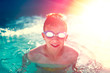 © sakkmesterke - Happy kid in swimming pool enjoying summer holiday in sunset, vintage style