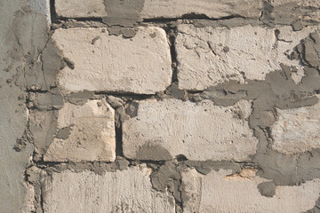 The background of cement and blocks on the wall grey plain textured with cracks close up . The horizontal frame.