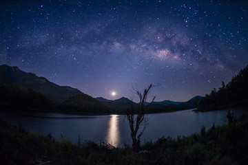 Wall Mural - milky way band across sky and moonrise over reservoir.