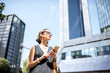© rh2010 - Lifestyle portrait of a businesswoman with phone in the modern district in Frankfurt city