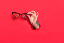 Female Hand In Paper Hole With Glasses