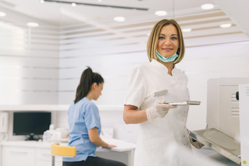 dentist with her assistant  preparing to sterilize instruments