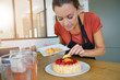© goodluz - Young woman in modern kitchen baking raspberry cake