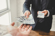 © Atstock Productions - Businessman giving money, united states dollar bills