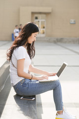 Wall Mural - Female college student in campus using a laptop