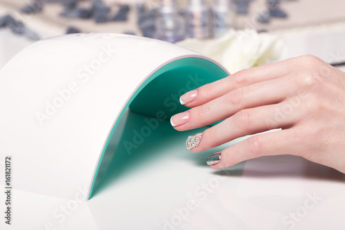 Photographie Closeup finger nail care by manicure specialist in beauty salon
