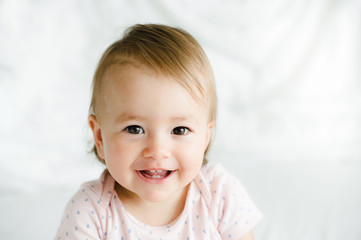 Beatiful baby girl smiling in bed