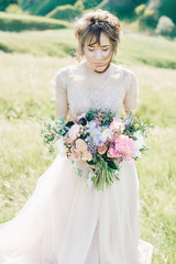 Wall Mural - Portrait of beautiful bride with bouquet in nature. fine art photography.