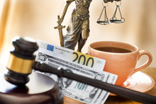 Law Concept. Gavel, Statue, Money And Coffee On Wooden Table 
