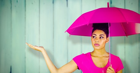 Canvas Print - Composite image of young woman carrying pink umbrella 