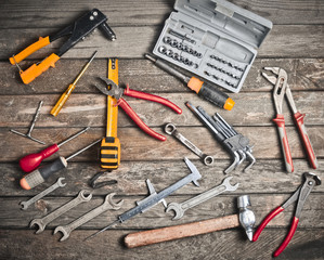 Wall Mural - A working tool close-up on a wooden texture table. Wrench, screwdrivers,  hammer, pliers. Top view. Flat lay. 
