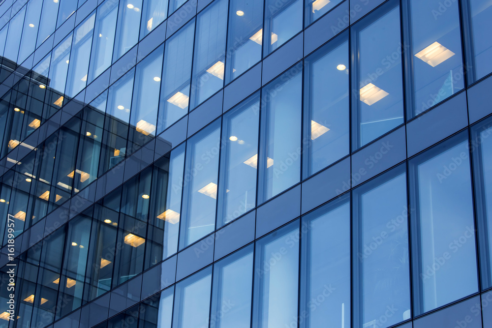 office building windows with inner artificial lamplight in blue color ...